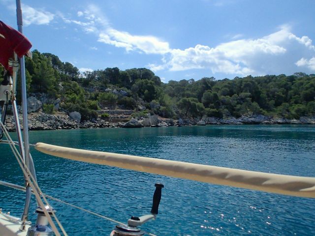 A view of the bay looking east. Crystal clear waters, good holding and plenty of rocks for tying stern lines.