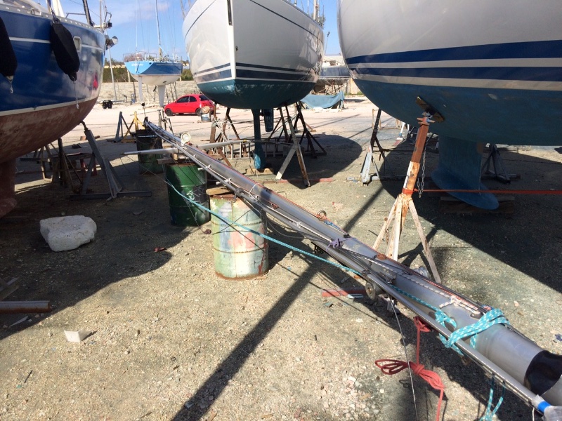 Baby-oiled mast with rigging attached waits for the crane.